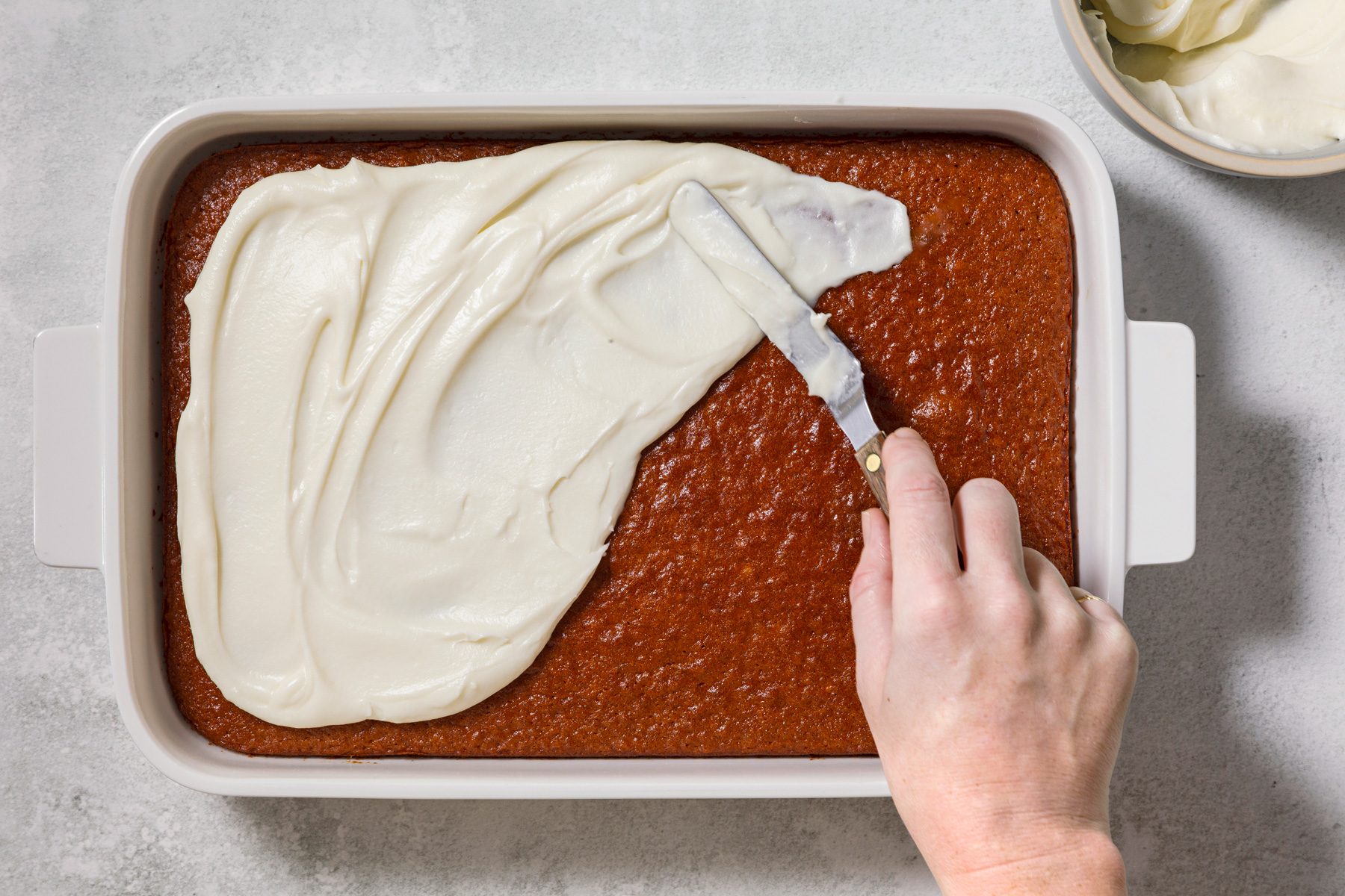 Spread cream cheese frosting over cooled cake.