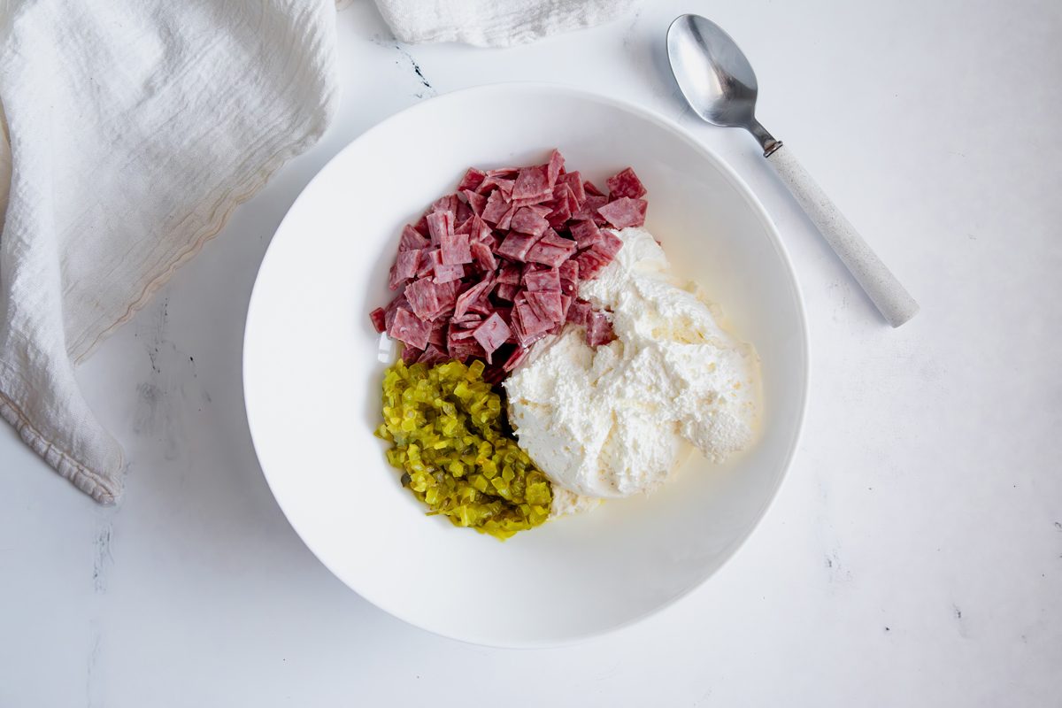 Overhead shot for Taste of Home Salami Roll Ups with ingredients in a large bowl before being mixed.