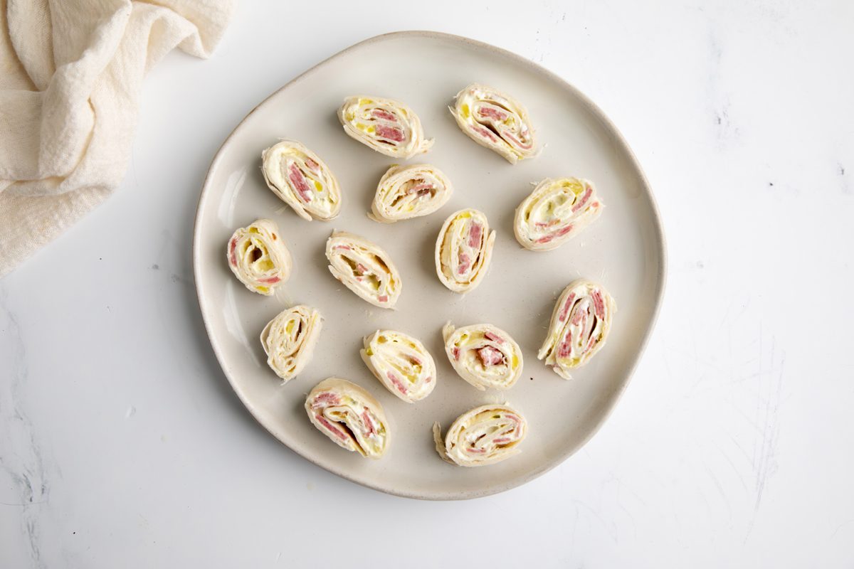 Overhead beauty shot for Taste of Home Salami Roll Ups being served on a large plate.