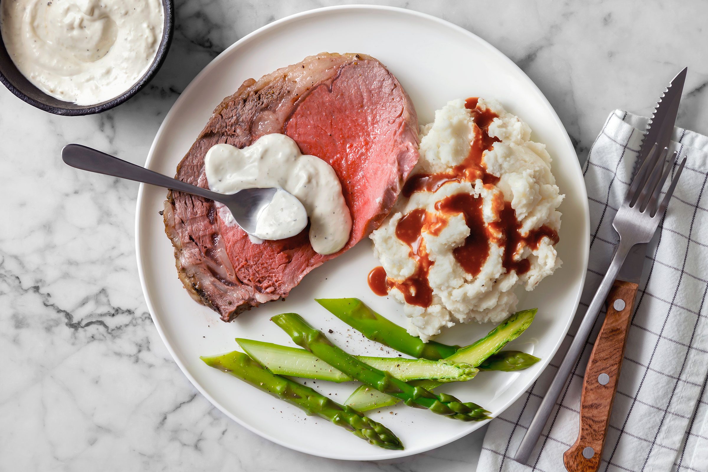 Salt Encrusted Prime Rib slice with horseradish sauce and asparagus.