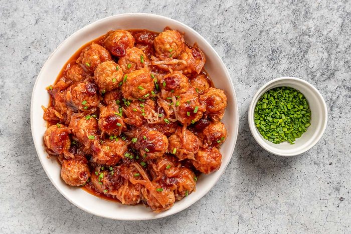 Taste of Home Sauerkraut Meatballs photo of the cooked meatballs topped with chives.