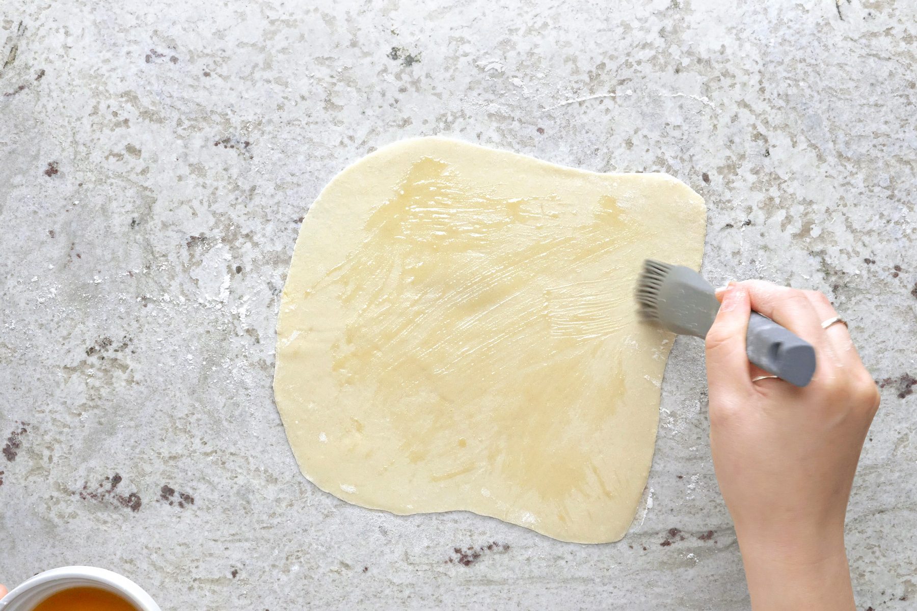 Brushing the flat dough.