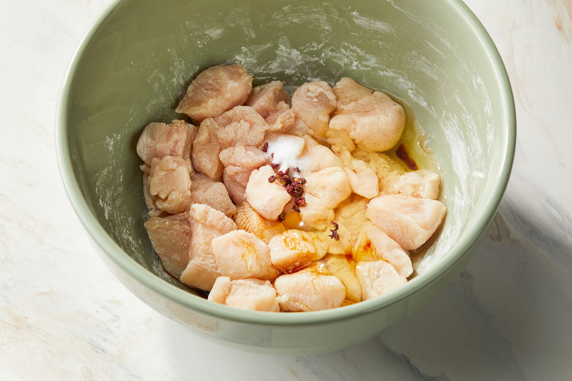 Mixing in egg whites, soy sauce, peppercorns and salt until well combined