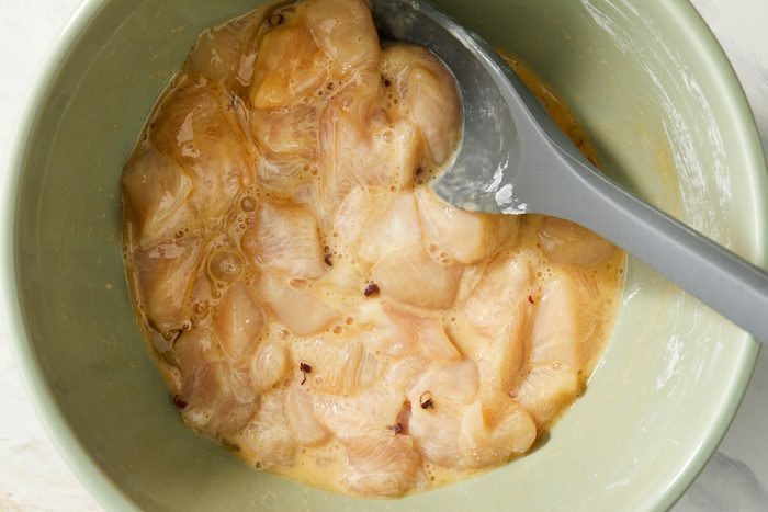 Mixing in egg whites, soy sauce, peppercorns and salt with a spoon