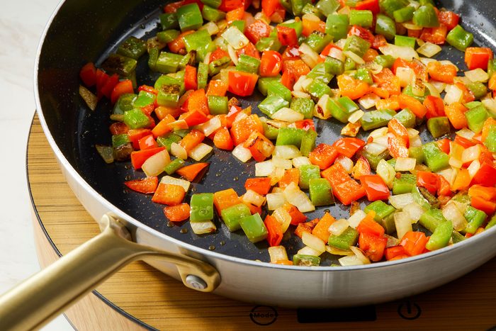 Heating 2 tablespoons oil in the hot skillet or wok, Added bell peppers and onion then cook until crisp tender
