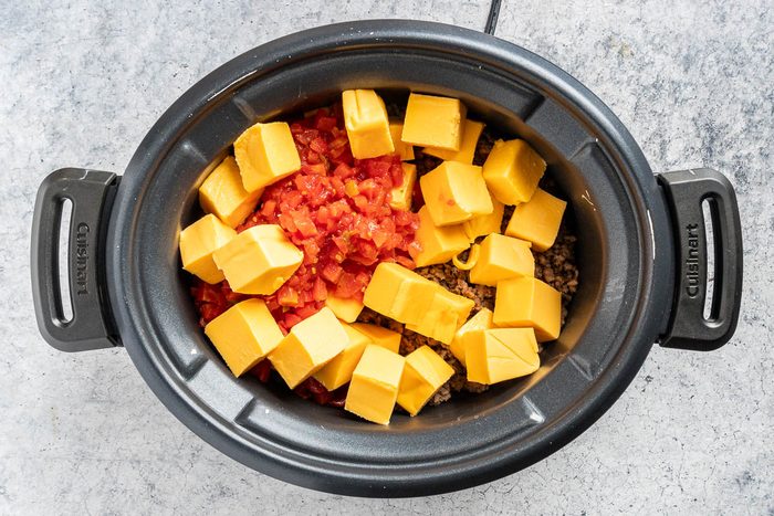 Taste of Home Slow Cooker Cheese Dip photo of the cheese and tomatoes added to the slow cooker.
