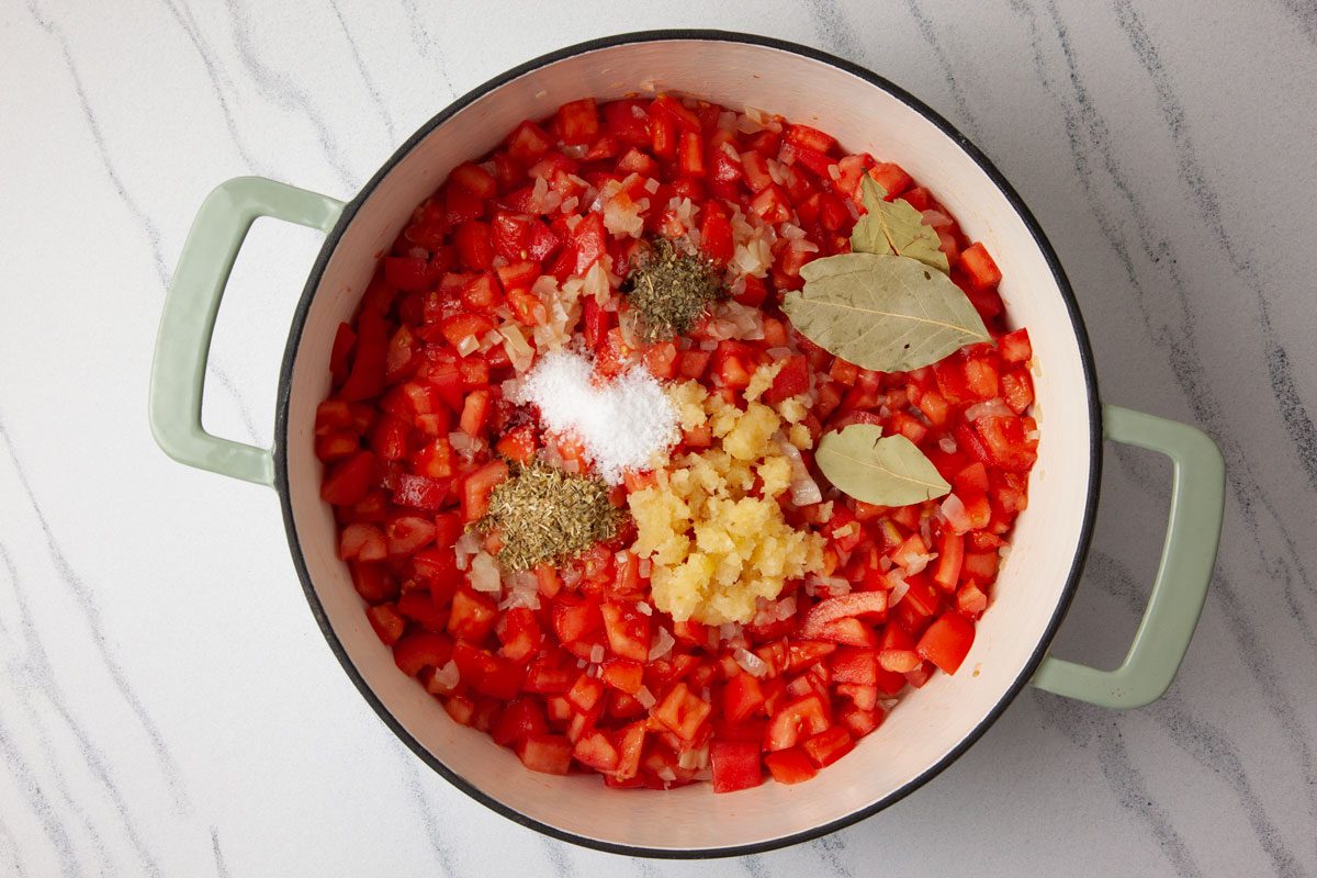 Step 2 of Taste of Home Spaghetti Sauce Without Meat is to add the tomatoes, dried herbs, garlic, salt, bay leaf