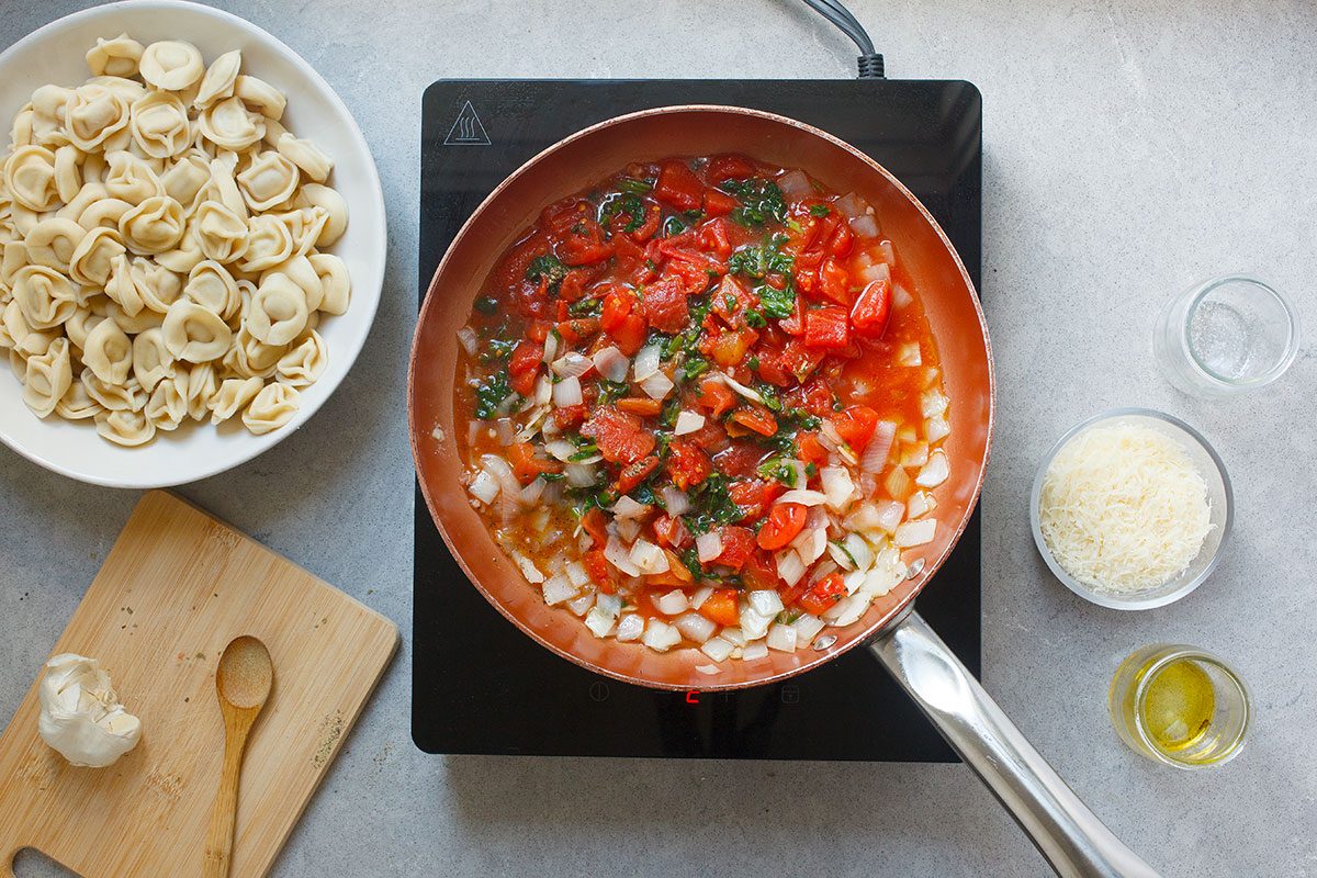 Onions, spinach, tomatoes and onions in skillet