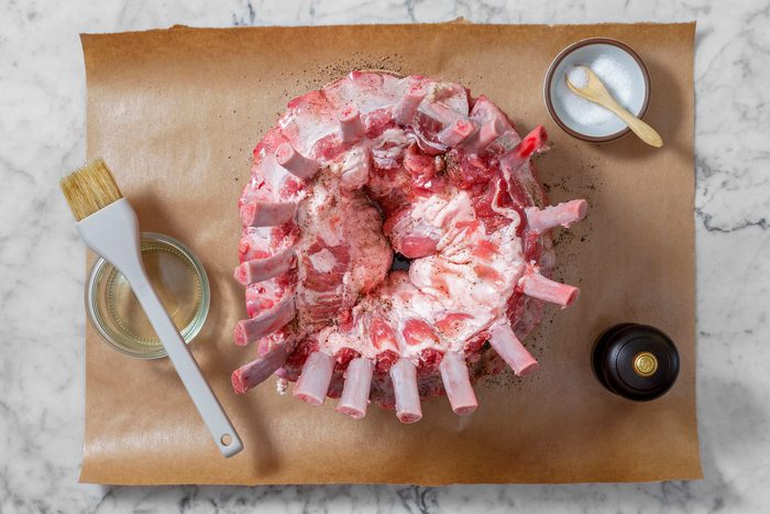 Overhead shot of rub entire roast with 1 teaspoon salt and 1/2 teaspoon pepper; brush 3 tablespoons oil; brush; marble surface.