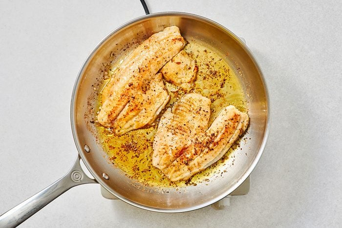 Cooked tilapia fillets in a large skillet