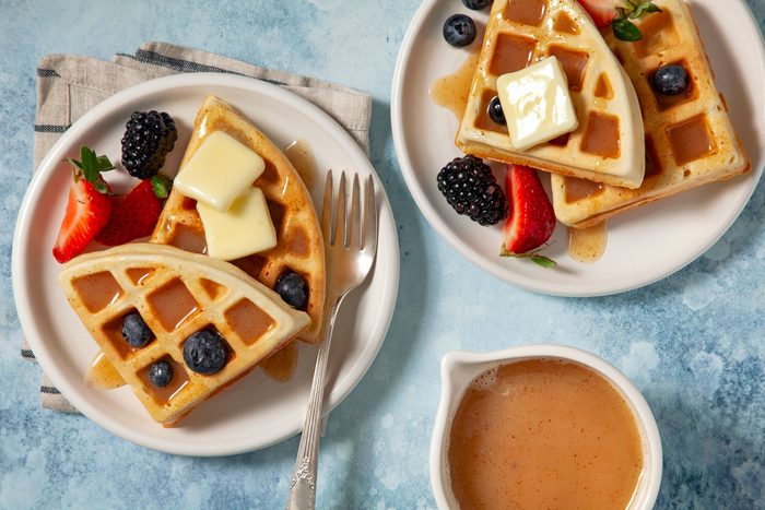 Waffle served in plates with berries, strawberries and butter