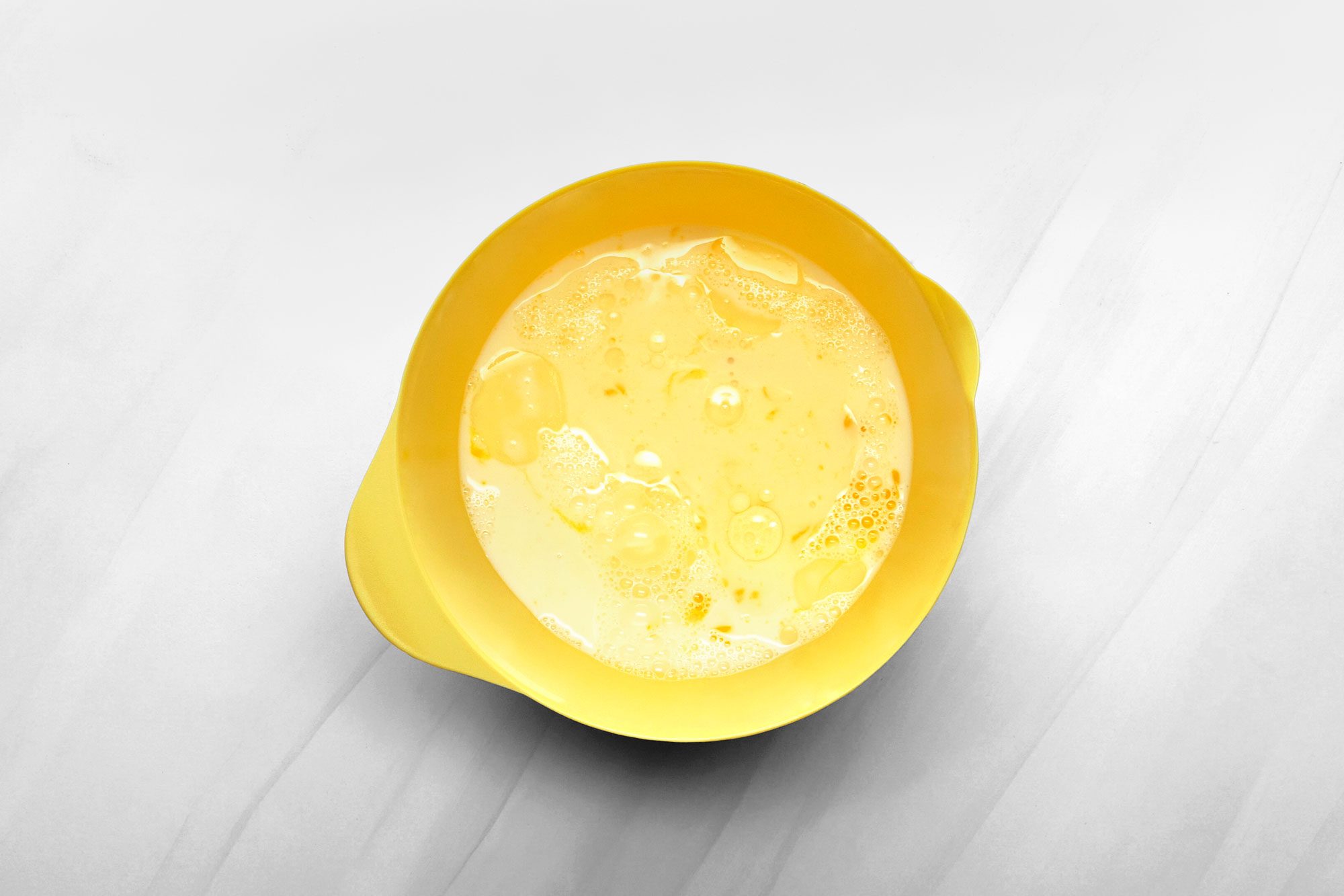 In a bowl, whisk together the egg yolks, milk and canola oil