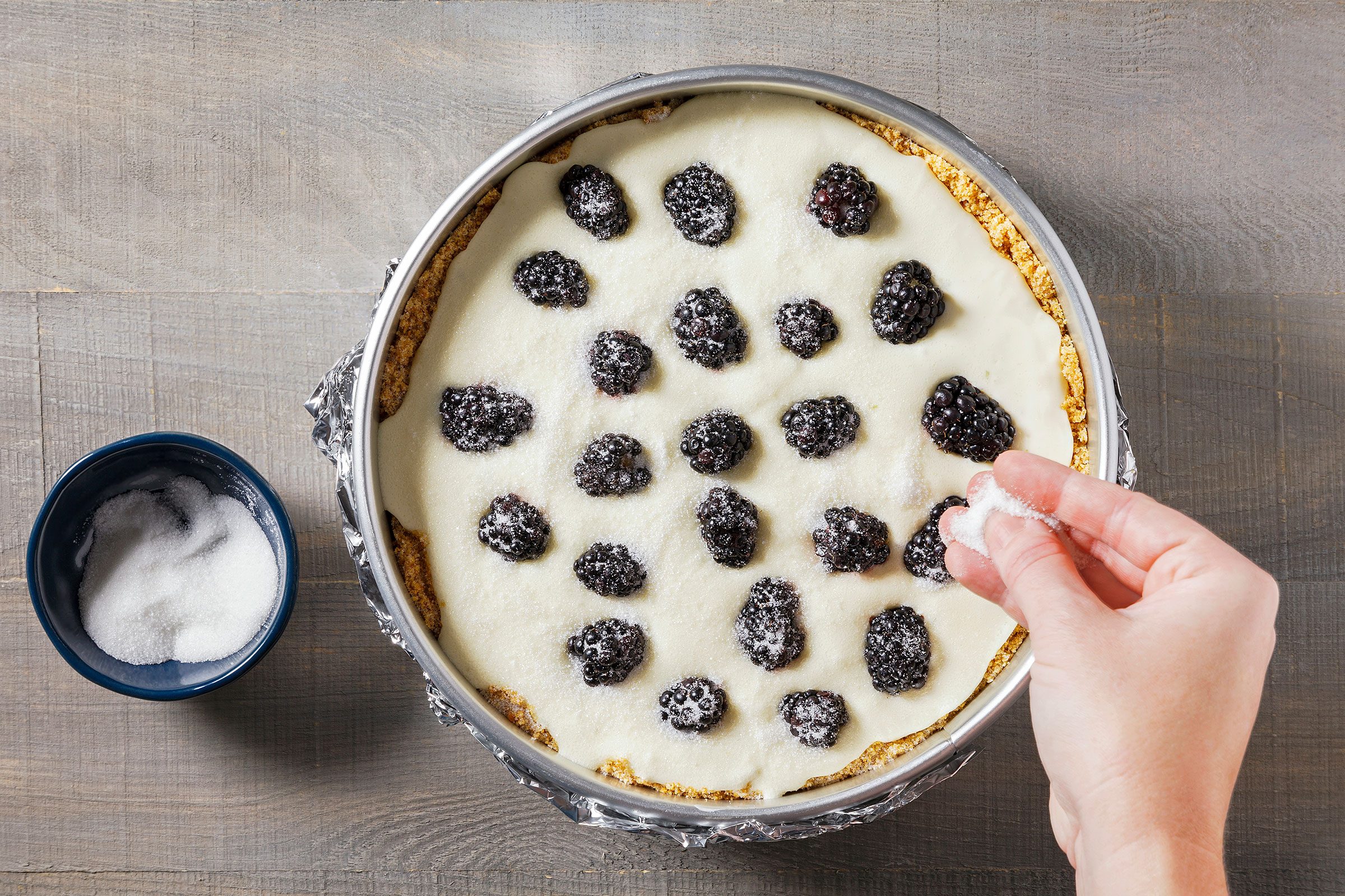 Blackberries on top of creamy cheesecake batter sprinkled with sugar on top