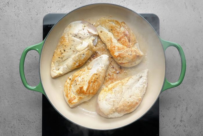 Browning the chicken breasts by tossing them on some hot oil in a large skillet