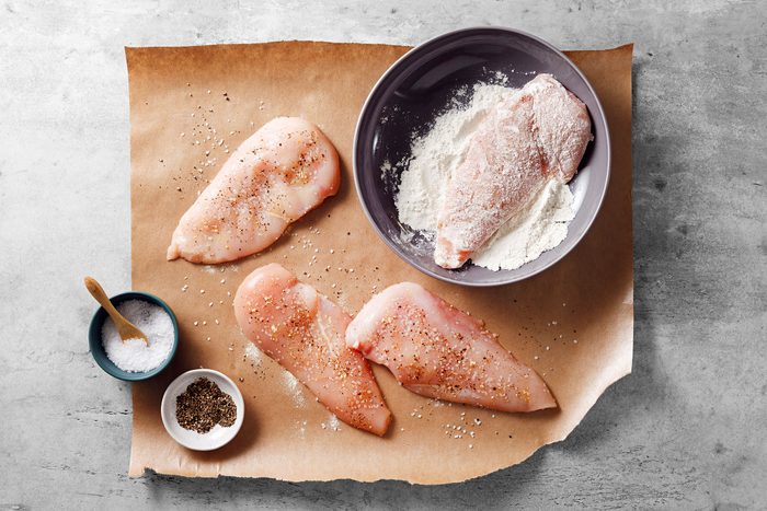Chicken breasts seasoned with salt and pepper and rolled into flour