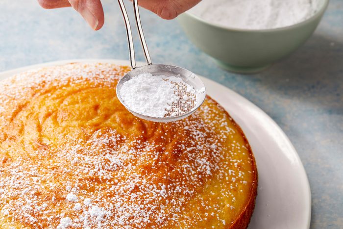 Dusting Lemon Olive Oil Cake with confectioners' sugar