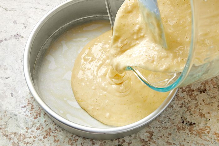 Transferring cake batter into greased cake pan