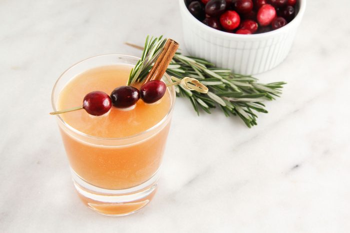 Naughty But Nice Cocktail served with a sprig of rosemary and cinnamon stick