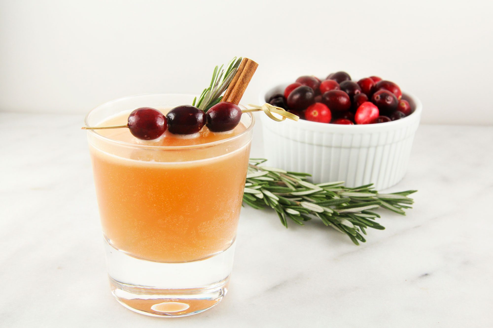 Naughty But Nice Cocktail served with a sprig of rosemary and cinnamon stick