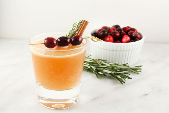 Naughty But Nice Cocktail served with a sprig of rosemary and cinnamon stick