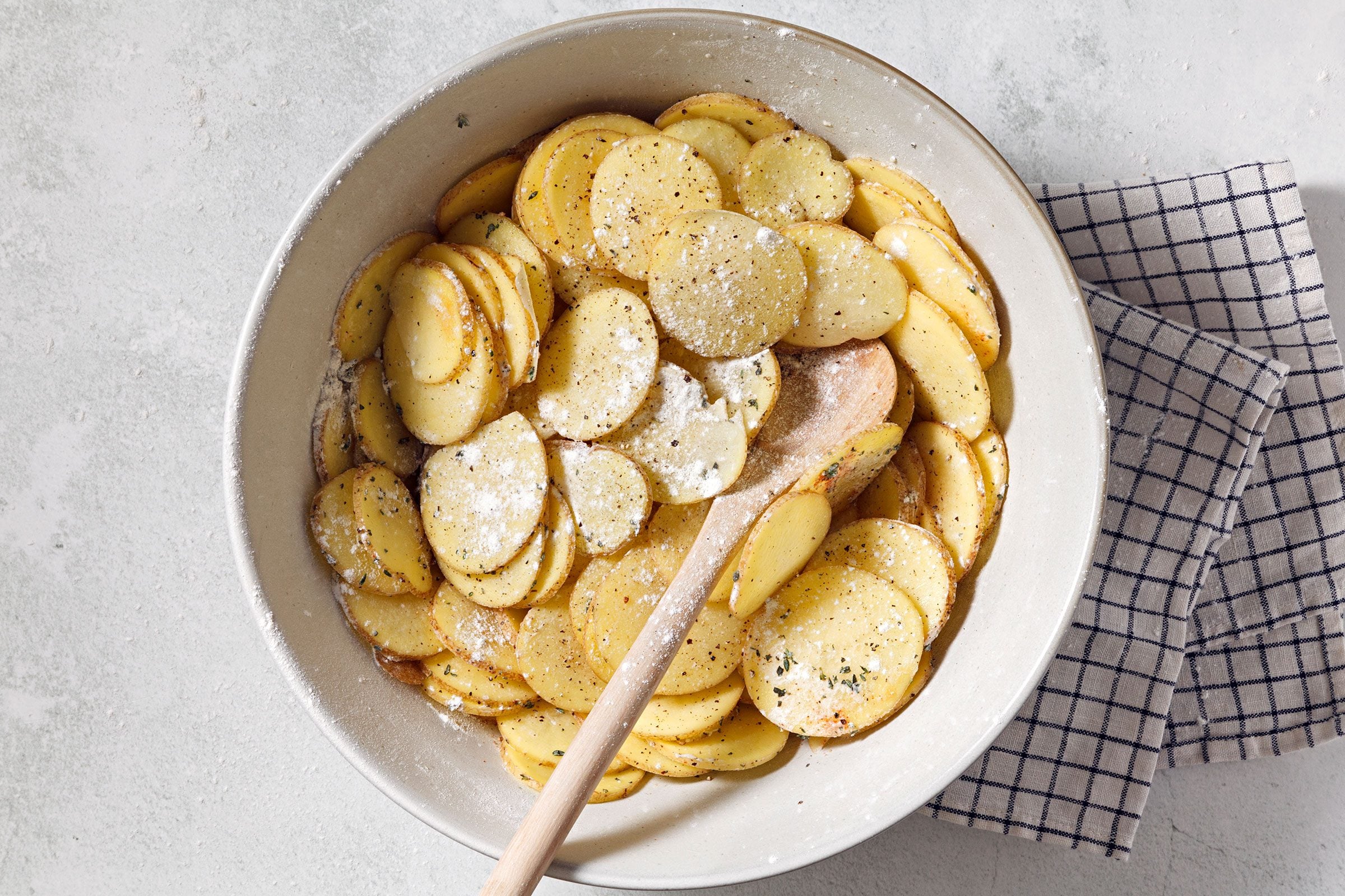 Combined flour, seasonings and sliced potatoes in a large bowl