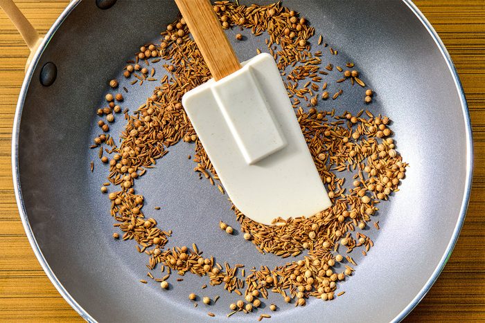 overhead shot of Toasting cumin and coriander seeds until seeds have darkened, stirring frequently