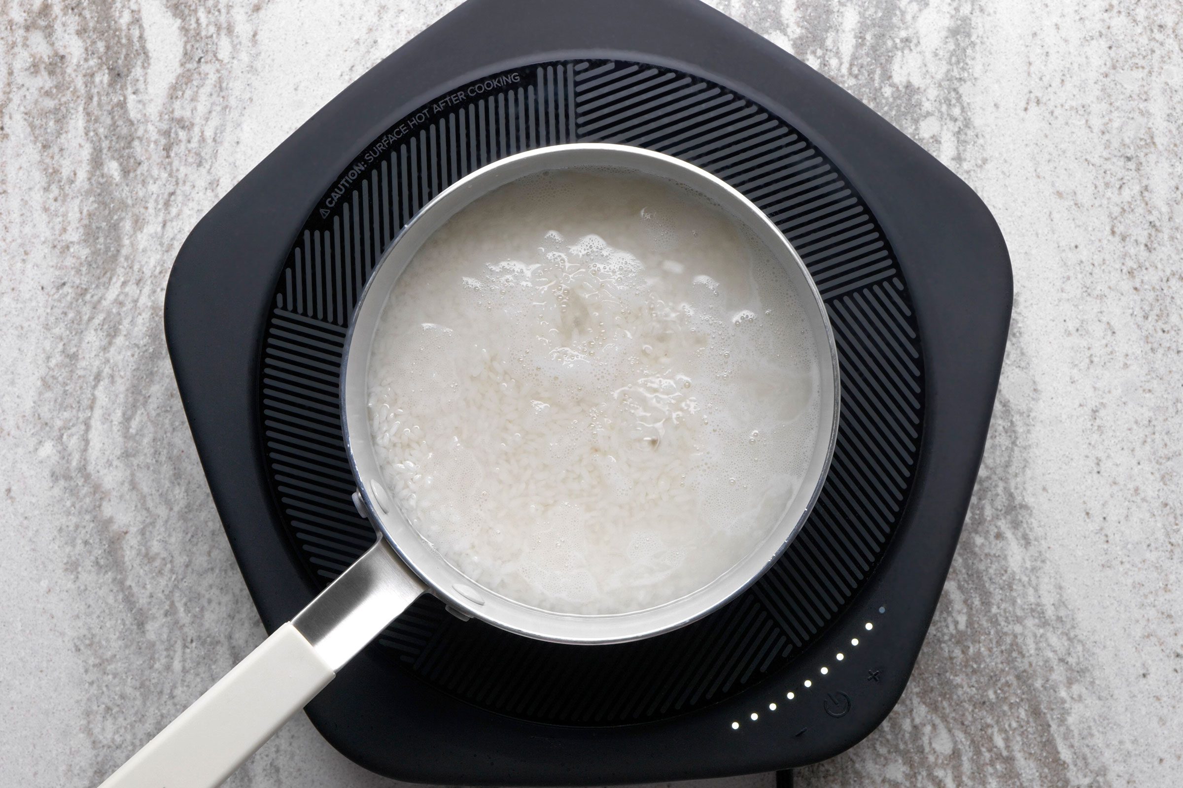 Boiling rice in a pan to make sushi rice
