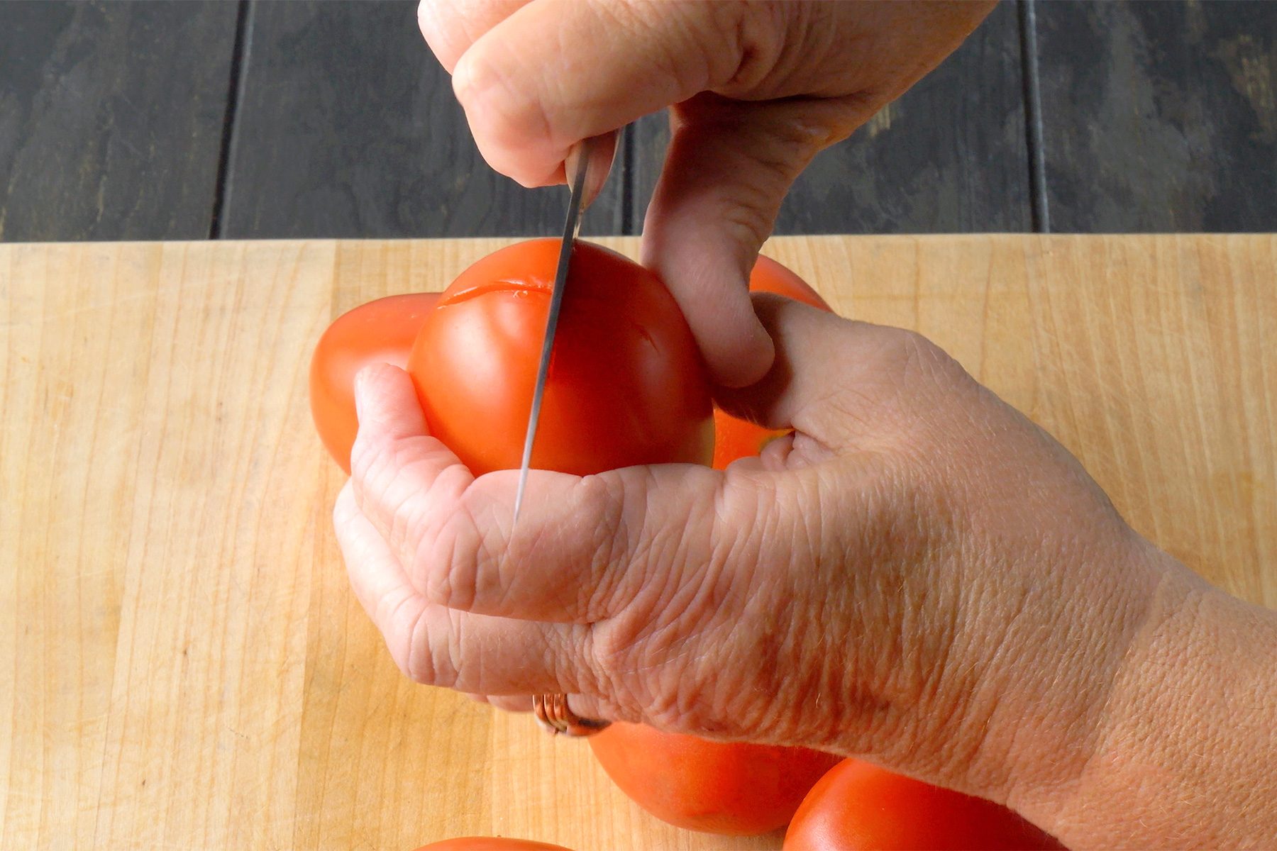 Score the bottom of each tomato.