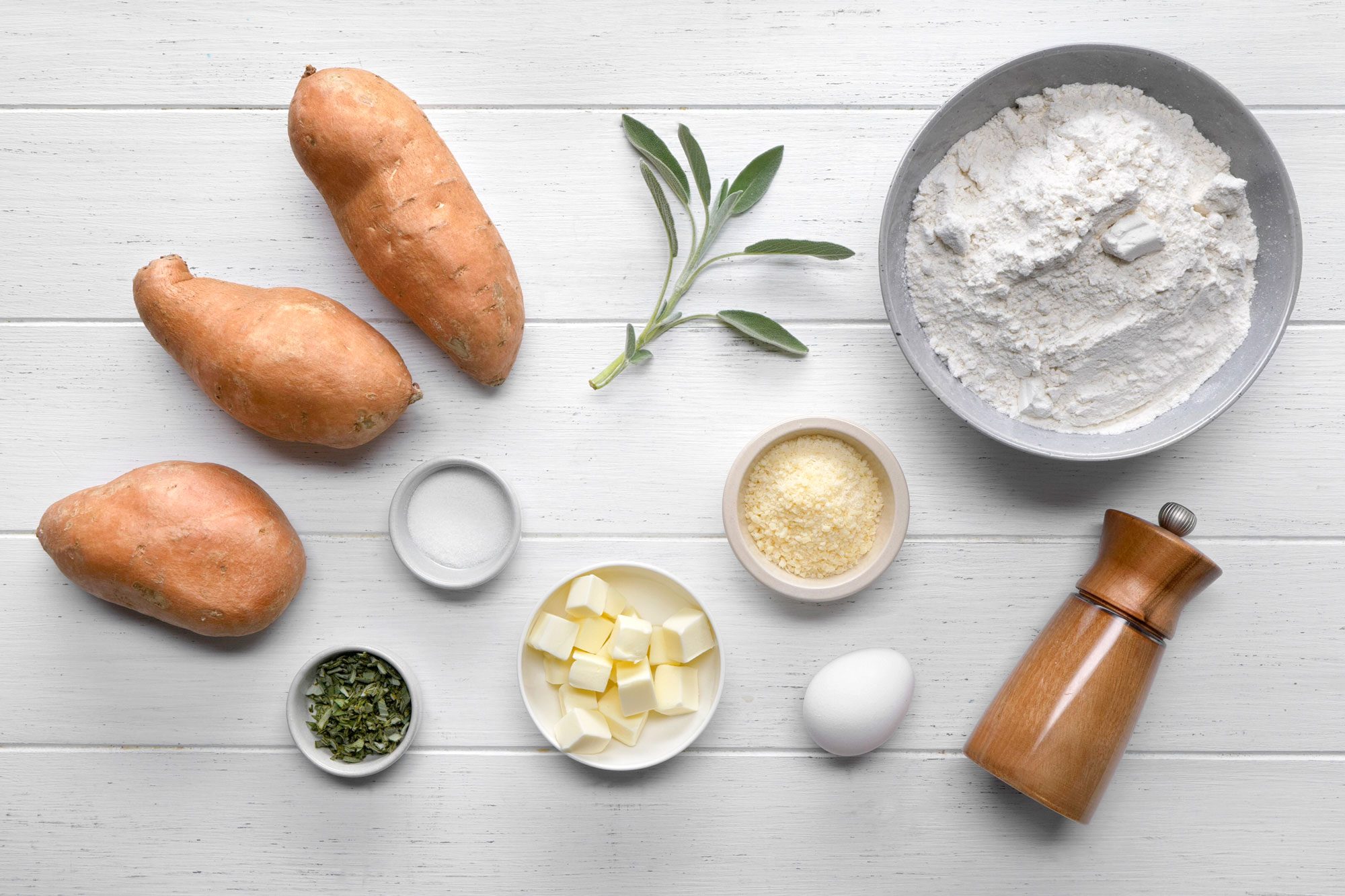 overhead shot of Sweet Potato Gnocchi ingredients placed over white wooden background