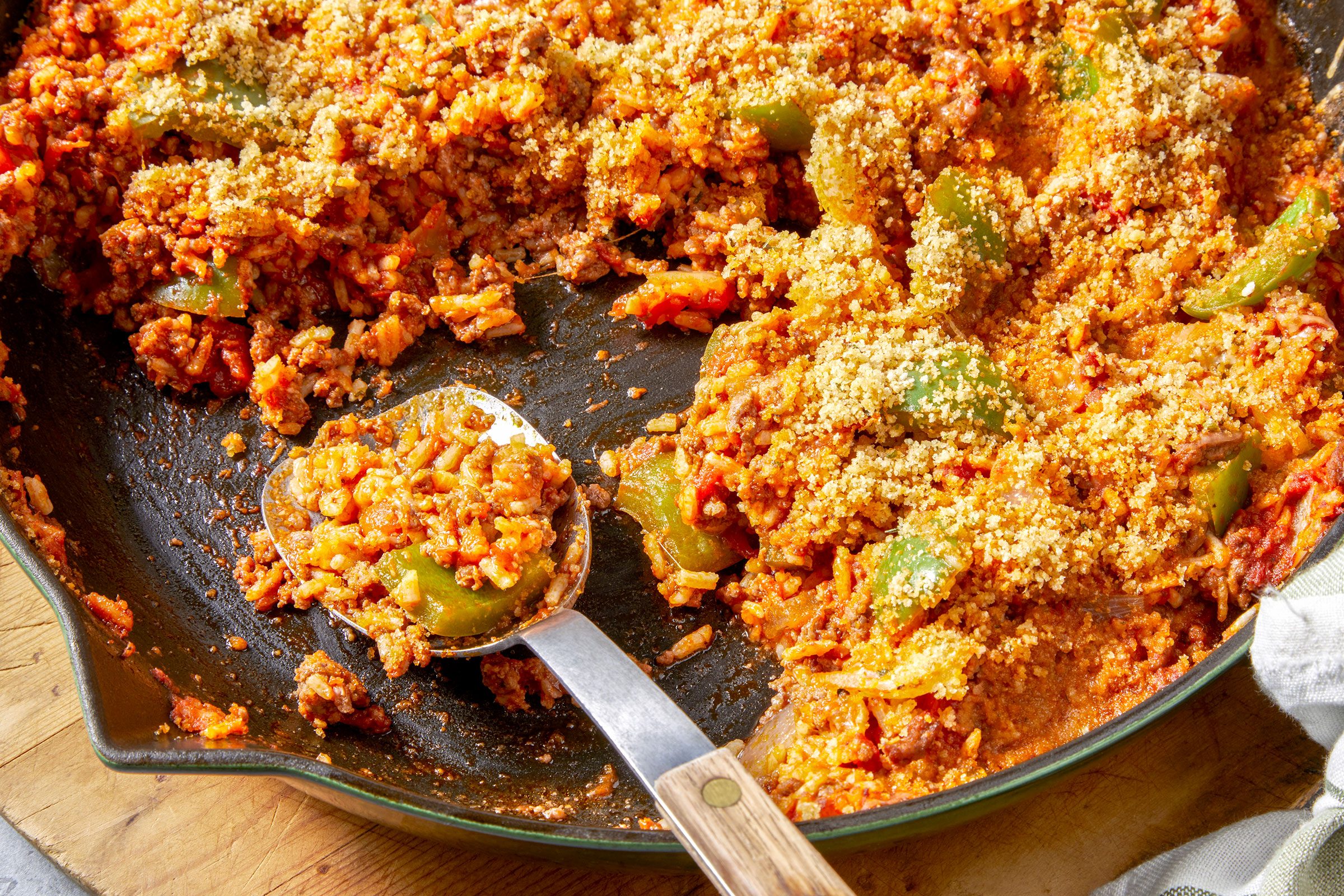 Unstuffed peppers in a large skillet with a serving spoon in it
