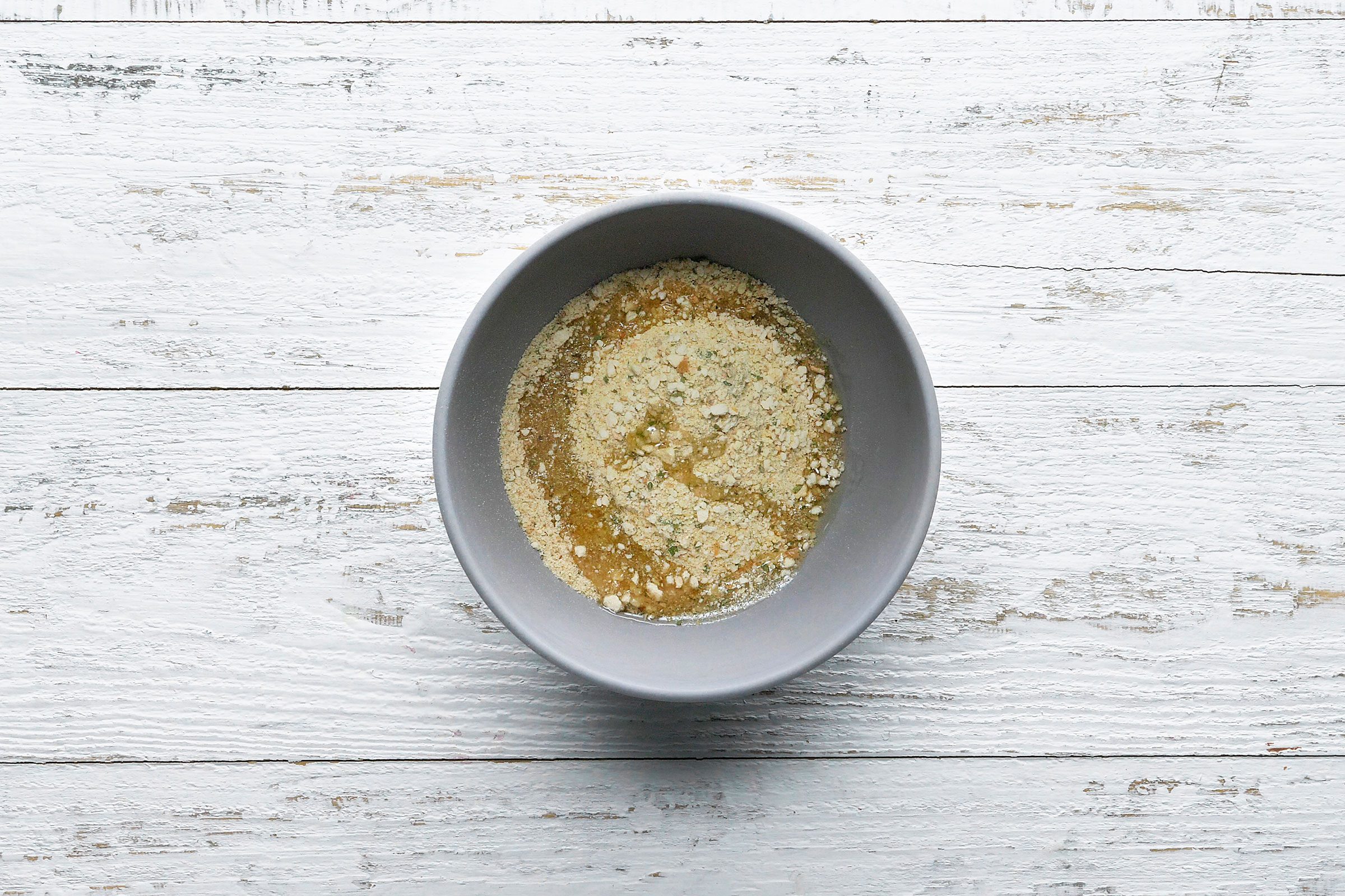 Bread crumbs and oil tossed in together in a small bowl
