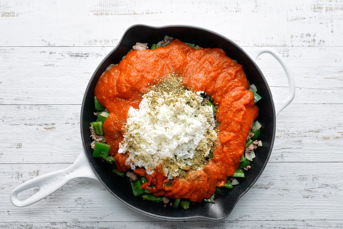 Rice, marinara sauce and seasonings added to cooked beef and green peppers in a large skillet