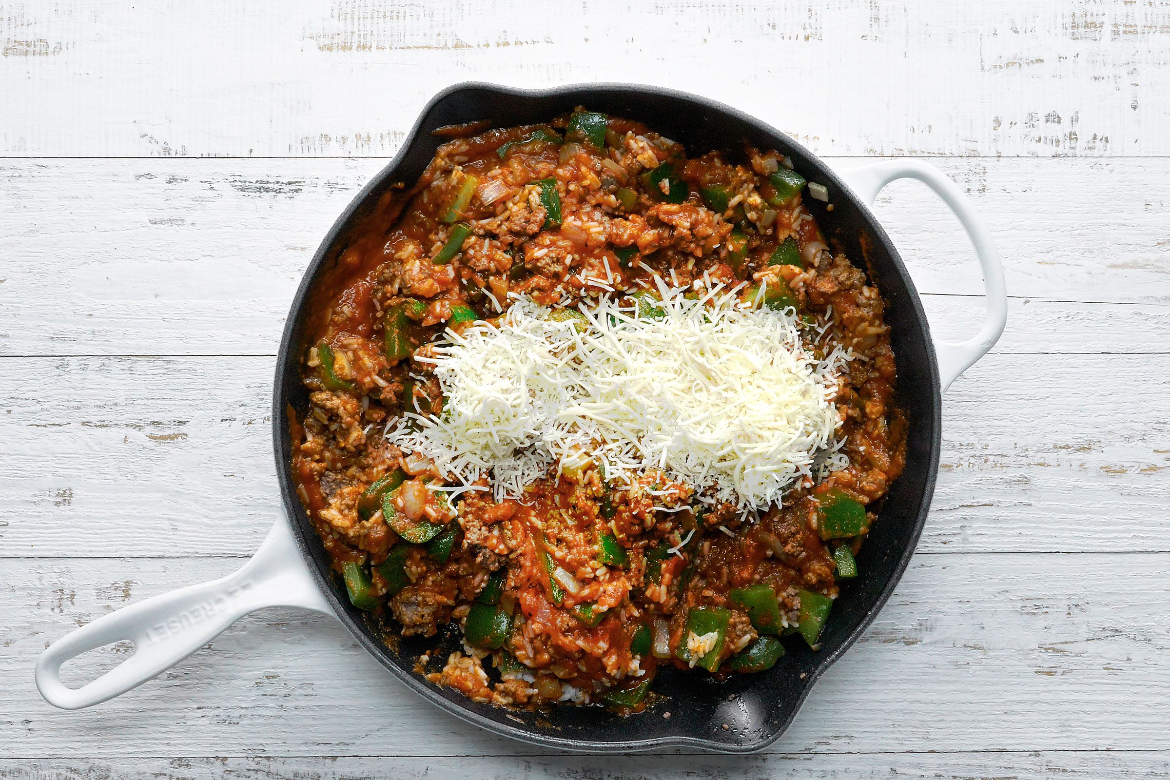 Cooked beef, rice, peppers and onions mixed together with grated cheese on top