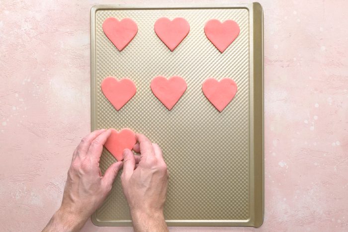 Heart shaped cookie dough placed on an non greased baking sheet
