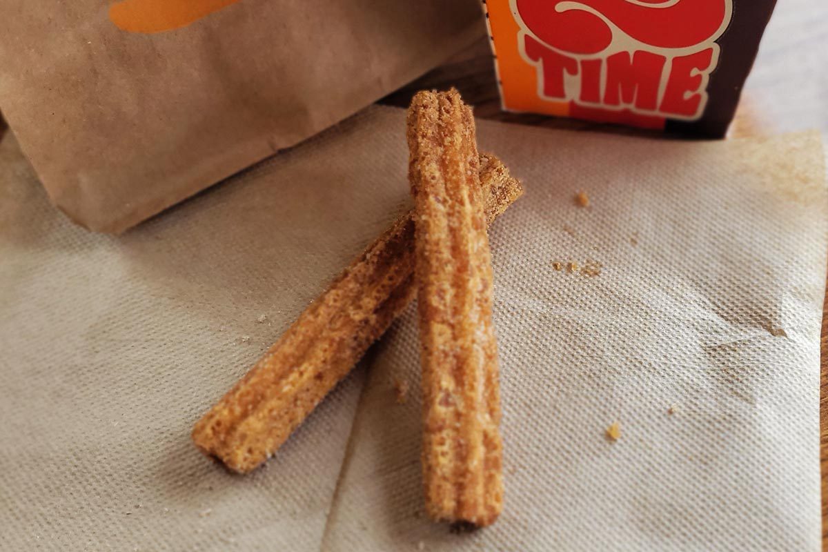 Two churro fries on a napkin