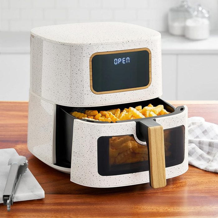 Pioneer Woman air fryer on a kitchen counter, open with french fries inside