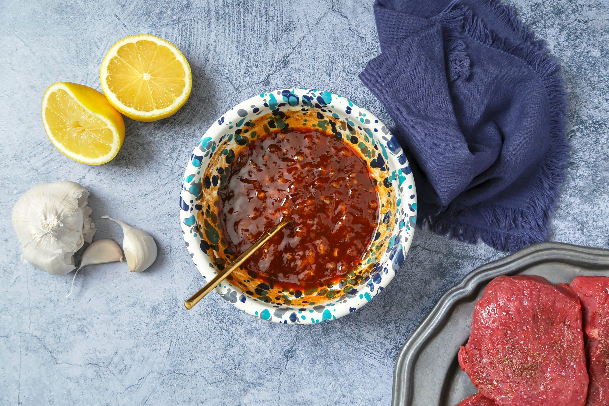 Sauce ingredients stirred together in a blue enamel bowl.