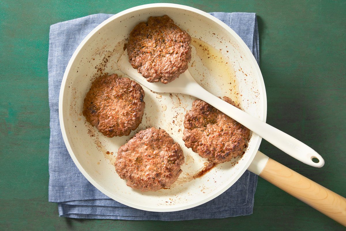 In a large skillet, heat oil over medium heat. Add burgers; cook