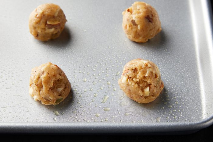 Cookie dough mixture shaped into half inch balls and placed on greased baking dish