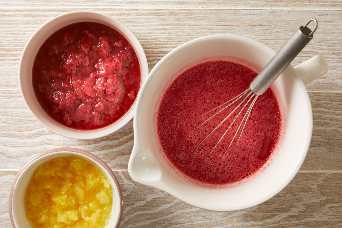 In a large bowl, dissolve gelatin in water. Add strawberries and pineapple.