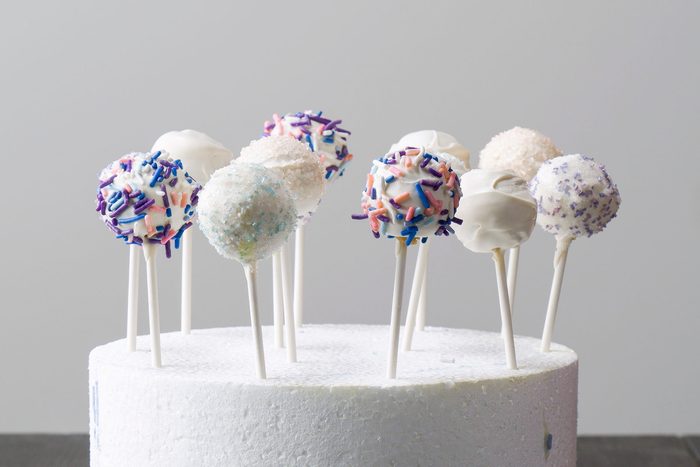 horizontal shot of cake pops displayed on top of a circular white thermocol stand