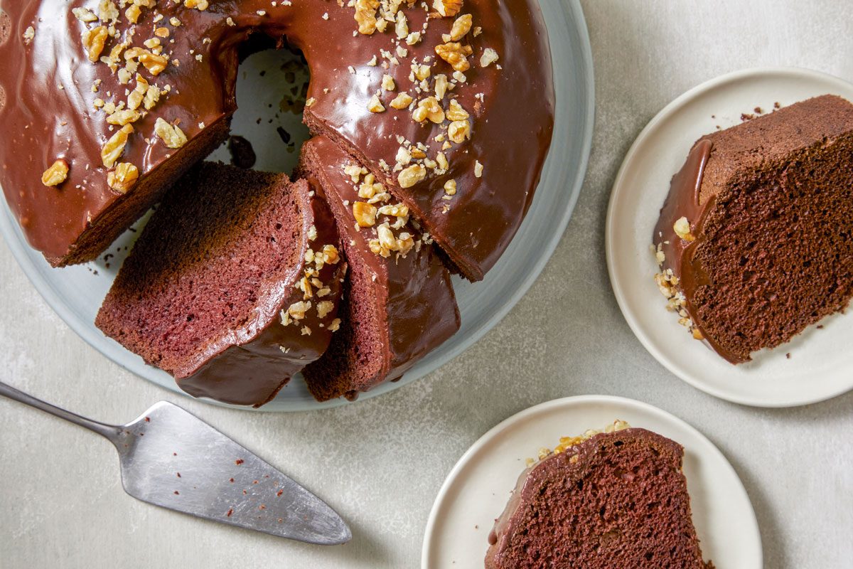 Top view shot of Chocolate Chiffon Cake; placed on a plate; cut into slices and served on two plates; cake knife; marble surface;