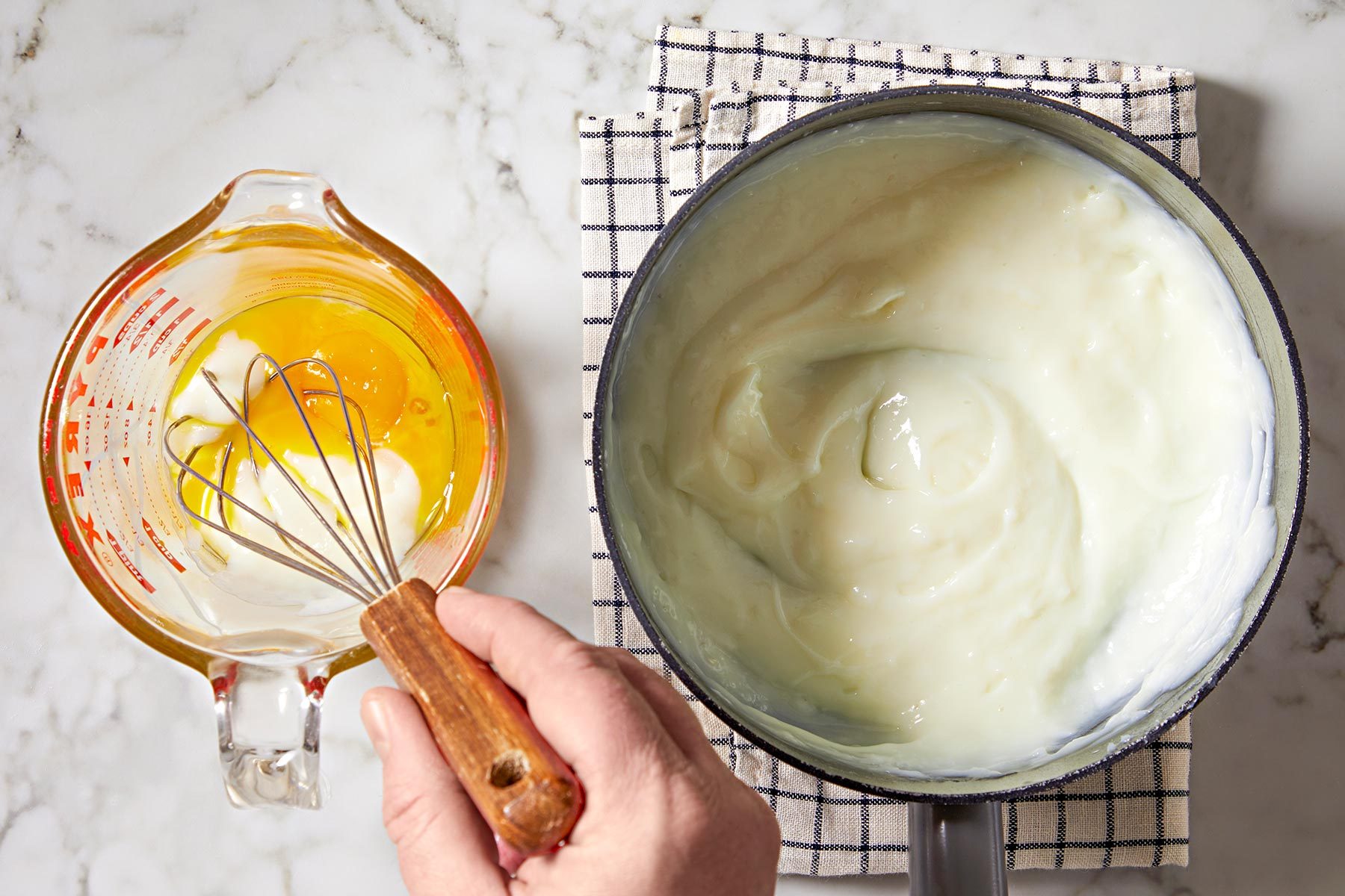 In a small bowl, whisk a small amount of hot mixture into egg yolks.