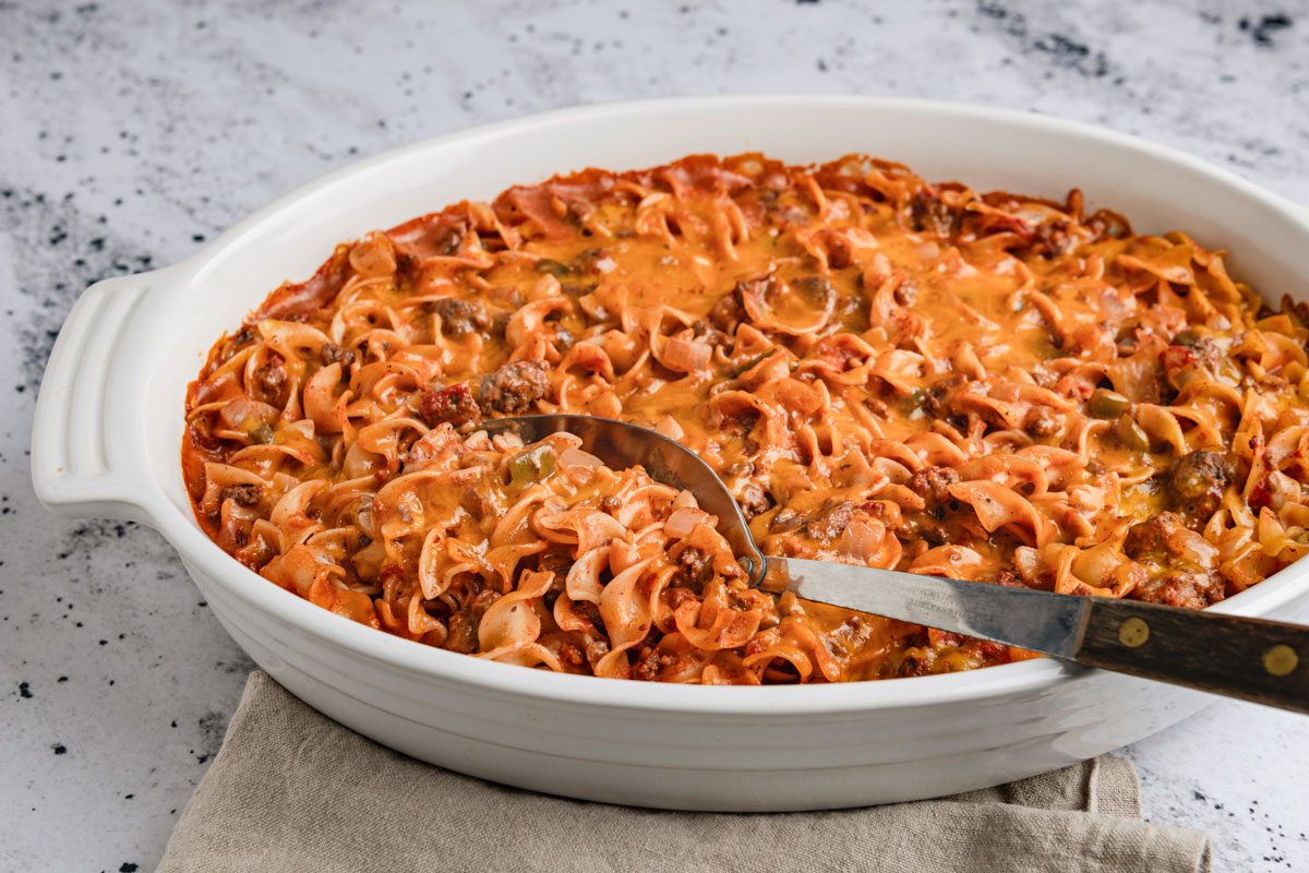 Table view shot of Marzetti; in a baking pan; serving spoon; napkin; marble surface;
