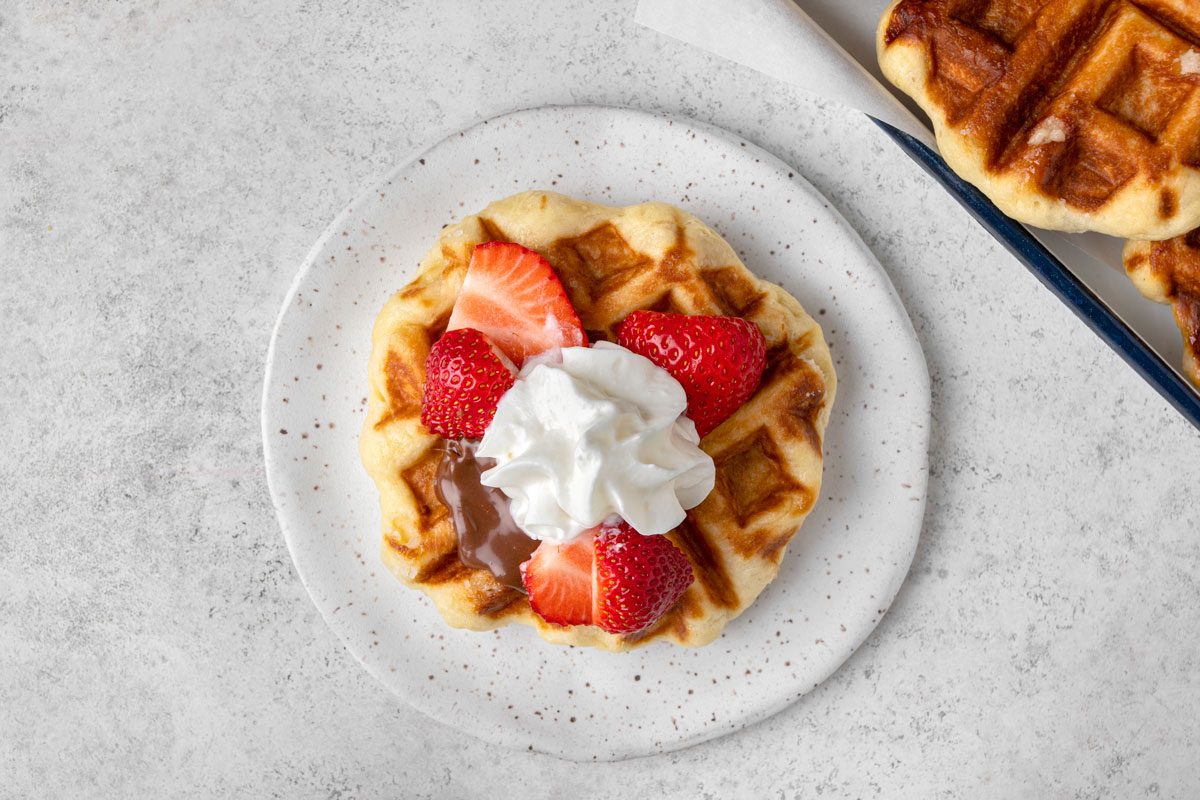 overhead shot of Liege Waffles topped with cream and fresh berries