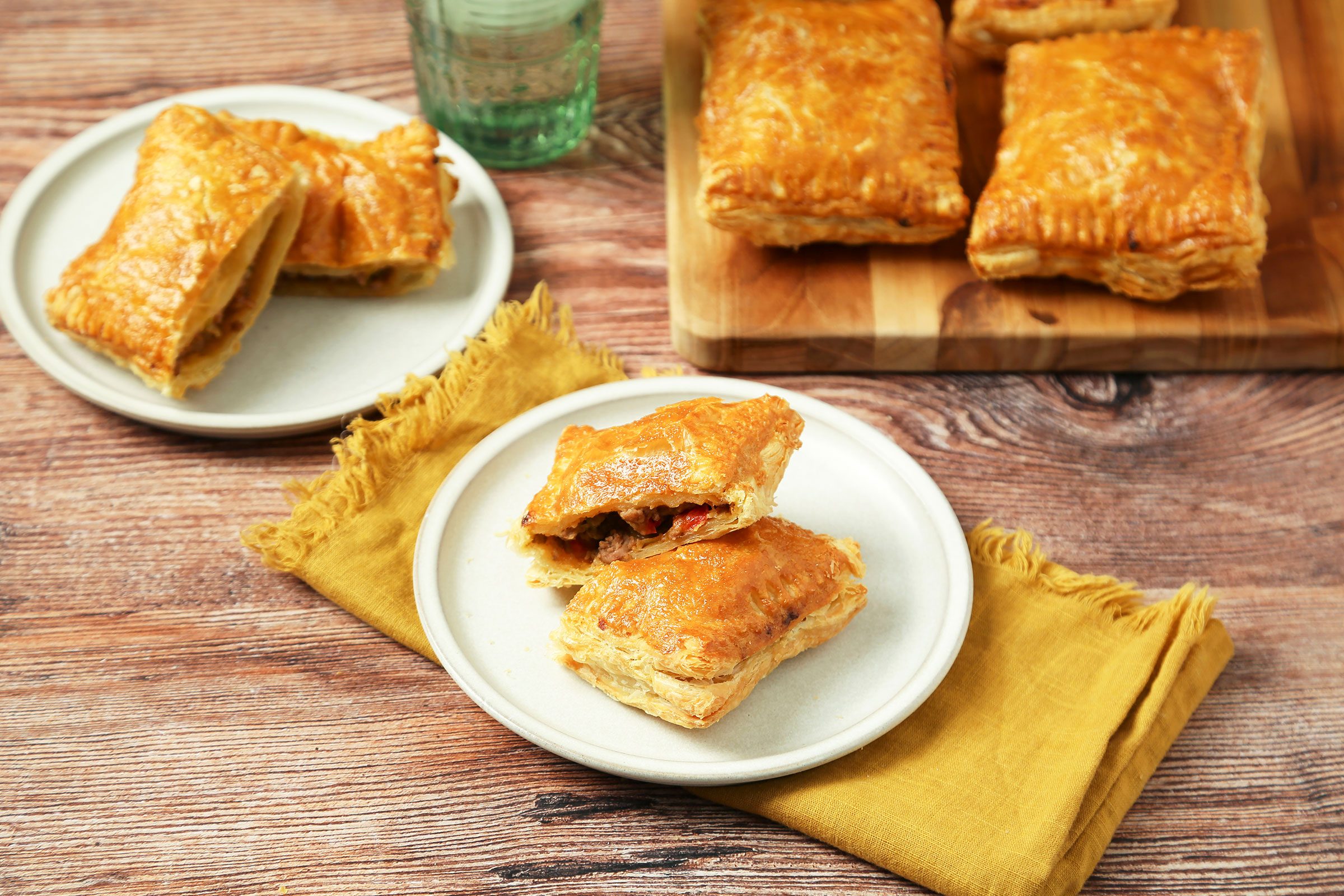 Louisiana Meat Pies served in white plates on a yellow fabric on wooden counter
