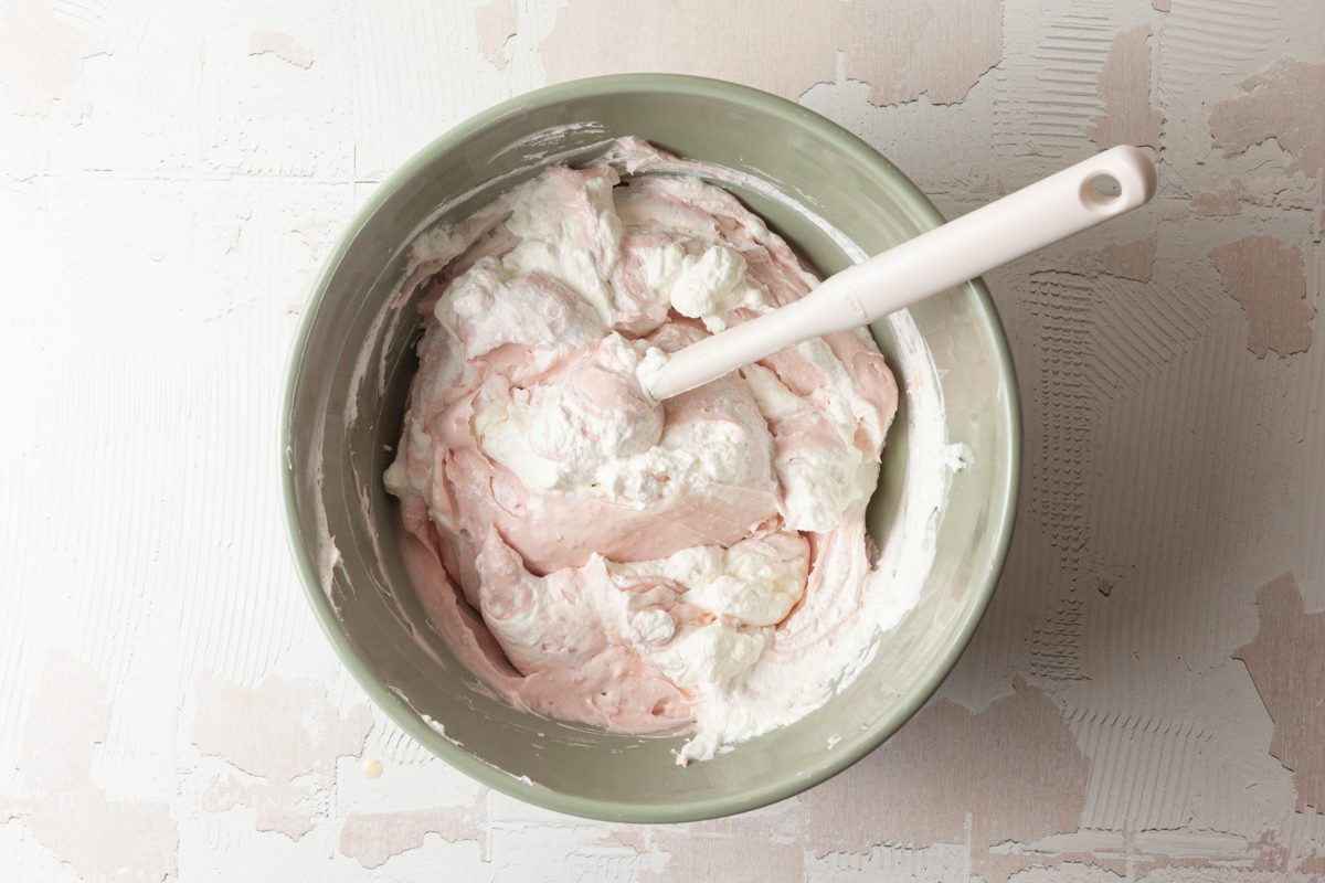 cream cheese mixture folded in with the whipped cream in a bowl