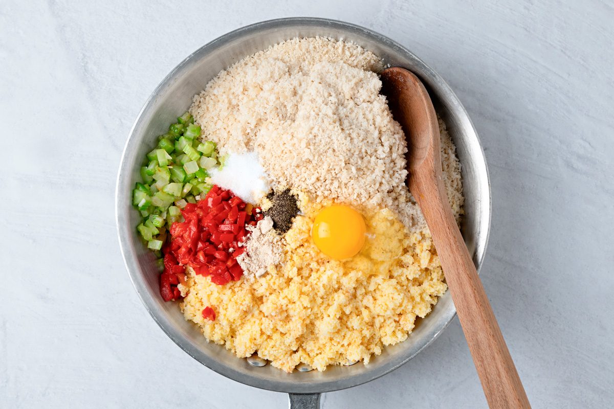 cornbread crumbs, bread crumbs, pimientos, chicken broth, egg, poultry seasoning, 1/2 teaspoon of salt and 1/4 teaspoon of pepper added to skillet