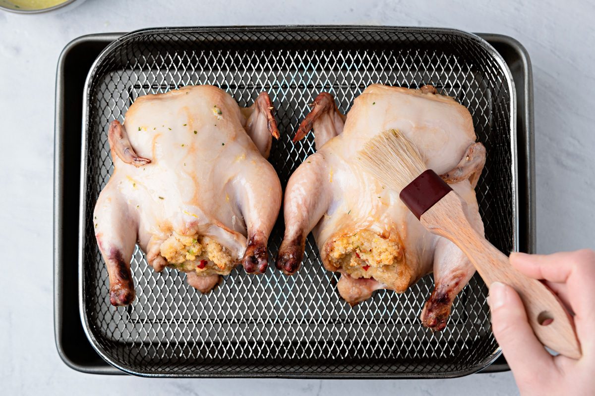 stuffed hens being brushed with butter mixture