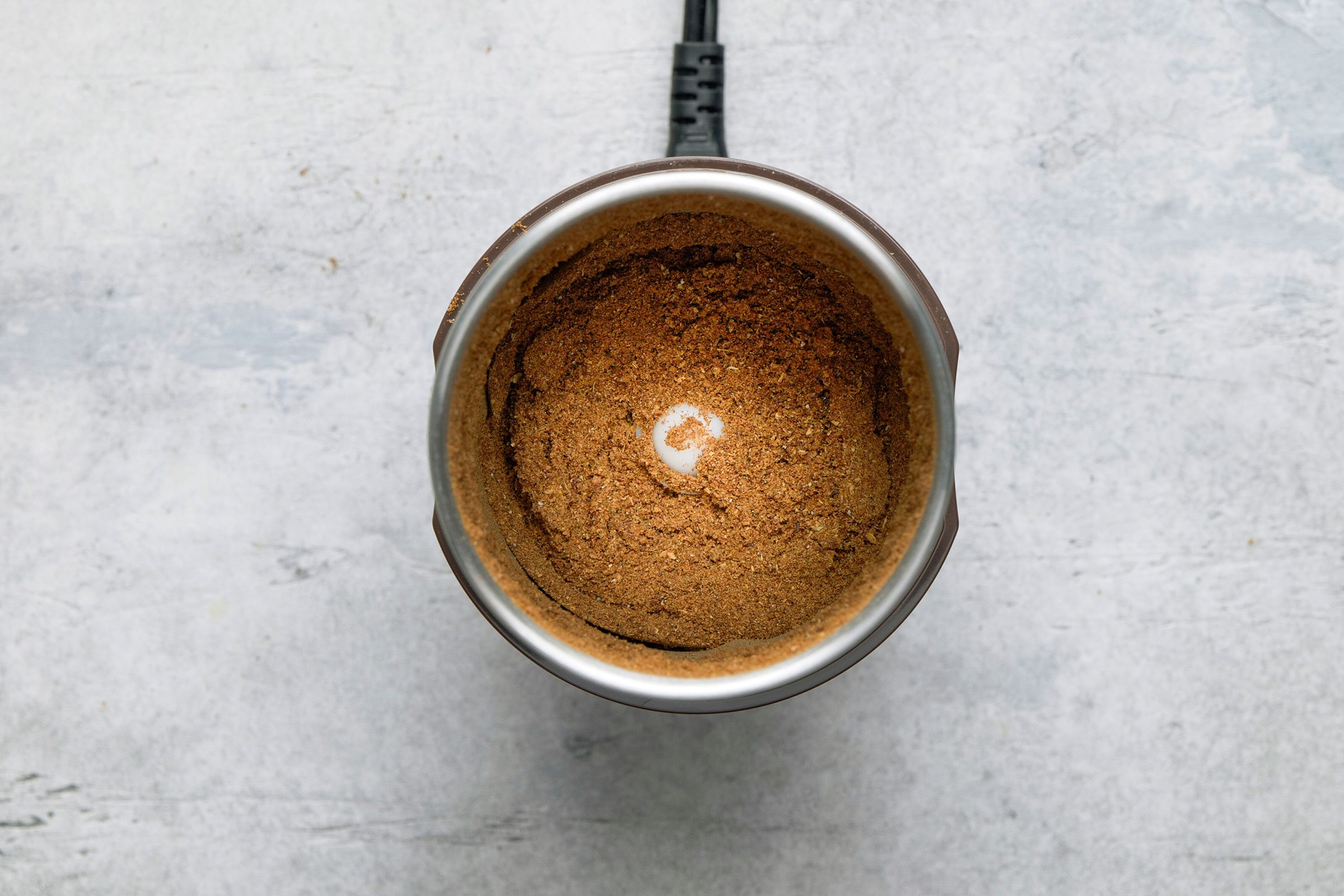 Toasted spices put in a grinder to finely grind them to powder